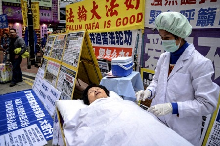 2013年1月12日，法轮功学员在香港购物区模拟中共活摘器官。(ANTONY DICKSON/AFP/Getty Images)