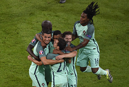 2016年欧洲杯第一场半决赛7月6日在里昂球场展开争夺，葡萄牙队以2球轻取威尔士。图为葡萄牙前锋C罗（左）得分后和队友拥抱。(PHILIPPE DESMAZES/AFP)