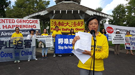 图：集会活动组织者之一刘女士向观众展示9,000份“诉江”签名。（陈新宇/大纪元）