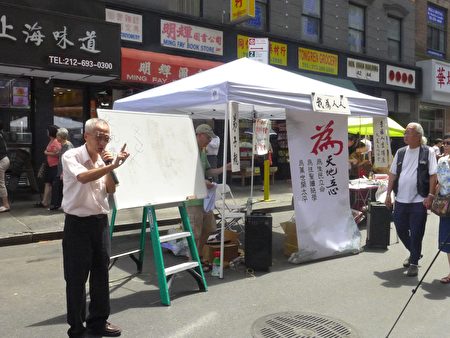 梁先生站在烈日下,苦口婆心的向過往民眾宣講家庭教育的重要。