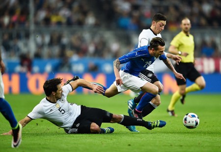 MUNICH, BAVARIA - MARCH 29: Mats Hummels and Mesut Oezil of Germany challenge Federico Bernardeschi of Italy during the International Friendly match between Germany and Italy at Allianz Arena on March 29, 2016 in Munich, Germany. (Photo by Dennis Grombkowski/Bongarts/Getty Images)