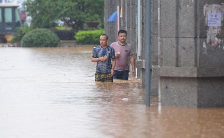 JIUJIANG, CHINA - JUNE 15: (CHINA OUT) Citizens walk in flood caused by rainstorms on June 15, 2016 in Jiujiang, Jiangxi Province of China. Heavy rainstorms continued to fall in many parts of China causing floods in Hunan, Henan, Guangxi, Guizhou, Guangdong and other places these days. (Photo by Hu Guolin/Getty Images)