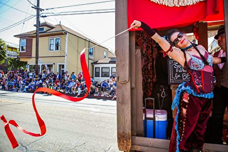 A woman from the "Soiled Dove" float waves to the crowd during the 4th of July Parade in Alameda, California on Monday, July 4, 2016. / AFP / GABRIELLE LURIE (Photo credit should read GABRIELLE LURIE/AFP/Getty Images)