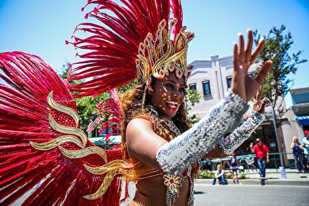 TOPSHOT - A woman in costume waves to the crowd during the 4th of July Parade in Alameda, California on Monday, July 4, 2016. / AFP / GABRIELLE LURIE (Photo credit should read GABRIELLE LURIE/AFP/Getty Images)