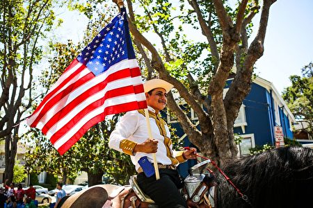 A man carries a flag as he rides a horse during the 4th of July Parade in Alameda, California on Monday, July 4, 2016. / AFP / GABRIELLE LURIE (Photo credit should read GABRIELLE LURIE/AFP/Getty Images)