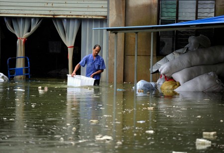This picture taken on July 5, 2016 shows a man making his way through a flooded area in Zongyang county, in east China's Anhui province. Heavy rain around China's Yangtze river basin has left 128 people dead and scores missing, media said on July 5, with more damage feared from a typhoon expected to land this week. / AFP / STR / China OUT (Photo credit should read STR/AFP/Getty Images)