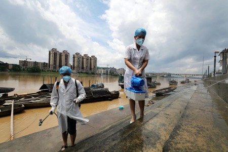 This picture taken on July 6, 2016 shows epidemic prevention workers spraying disinfectant after flooding in Rongan in southern China's Guangxi Zhuang Autonomous Region. Heavy rain around China's Yangtze river basin left at least 128 people dead with scores missing, media said on July 5, with more damage feared from a typhoon expected to land this week. / AFP / STR / China OUT (Photo credit should read STR/AFP/Getty Images)