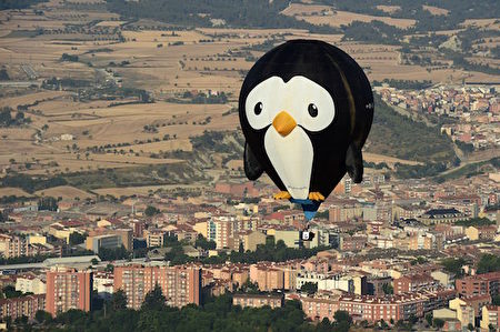 「天空飄過五個字：飛翔的企鵝~~」7月7日，巴塞羅那附近的伊瓜拉達舉行了第20屆歐洲氣球節，圖為一隻企鵝形的熱氣球，氣球上標有「#Fly Genguin」的字樣。(Photo credit should read LLUIS GENE/AFP/Getty Images)