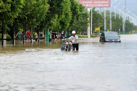 A man makes his way through a flooded street in Putian, in eastern China's Fujian province on July 9, 2016. A tropical storm made landfall in China on July 9, the country's national meteorological center said, a day after Super Typhoon Nepartak lashed Taiwan with powerful winds and torrential rain. / AFP / STR / China OUT (Photo credit should read STR/AFP/Getty Images)