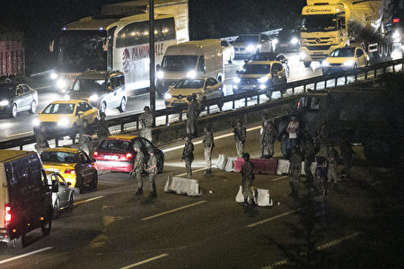 Turkish military control a road in Istanbul on July 16, 2016, after Turkish troops launched a coup. Turkish military forces on July 16 opened fire on crowds gathered in Istanbul following a coup attempt, causing casualties, an AFP photographer said. The soldiers opened fire on grounds around the first bridge across the Bosphorus dividing Europe and Asia, said the photographer, who saw wounded people being taken to ambulances. / AFP / GURCAN OZTURK (Photo credit should read GURCAN OZTURK/AFP/Getty Images)