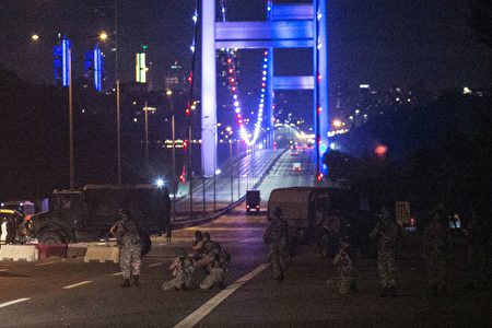 Turkish military control the entrance to the Bosphorus bridge in Istanbul on July 16, 2016, after Turkish troops launched a coup. Turkish military forces on July 16 opened fire on crowds gathered in Istanbul following a coup attempt, causing casualties, an AFP photographer said. The soldiers opened fire on grounds around the first bridge across the Bosphorus dividing Europe and Asia, said the photographer, who saw wounded people being taken to ambulances. / AFP / GURCAN OZTURK (Photo credit should read GURCAN OZTURK/AFP/Getty Images)