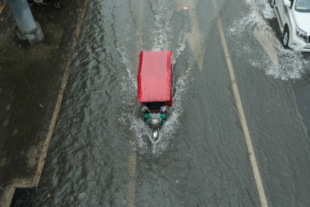 7月20日北京暴雨。圖為一輛三輪車在積水中艱難前行。 (STR/AFP/Getty Images)