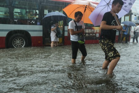 7月20日北京暴雨。圖為北京路上行人。(STR/AFP/Getty Images)