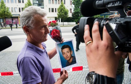 7月23日,一位受难者的父亲捧着儿子的照片。( Joerg Koch/Getty Images)