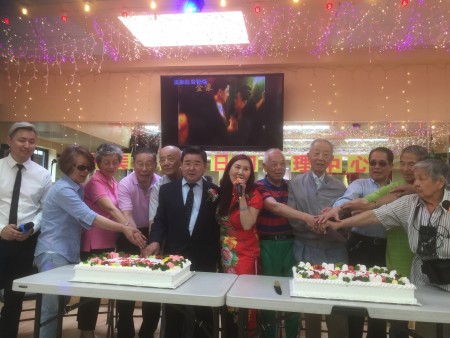 市议员顾雅明(左六)祝贺法拉盛Pople大道132-08号和美康成人日间护理中心分部乔迁之喜,并祝贺六、七月份生日的耆老生日快乐。右六为和美康经理谢怡祯。
