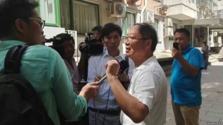 炎黃春秋雜誌社負責人胡德華在被強占的辦公地點外面接受外媒採訪。(網友提供)