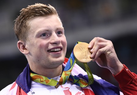 Britain's Adam Peaty poses on the podium with his gold medal after he broke the World Record in the Men's 100m Breaststroke Final during the swimming event at the Rio 2016 Olympic Games at the Olympic Aquatics Stadium in Rio de Janeiro on August 7, 2016. / AFP PHOTO / Martin BUREAU