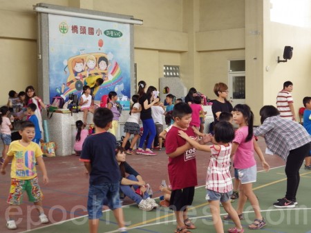 被安置在活動中心的許厝分校61位學生。在社工的帶領下開心的玩樂著。(廖素貞/大紀元)