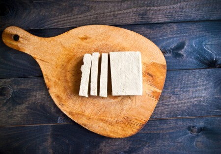 Slices of raw tofu on shabby cutting board(shutterstock) Slices of raw tofu on shabby cutting board(shutterstock)