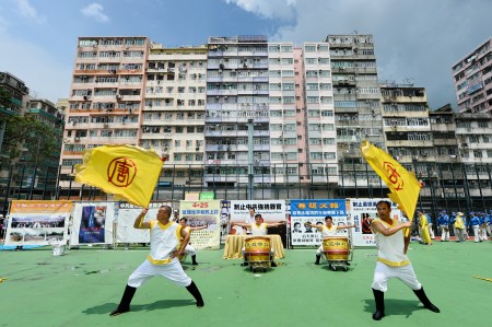 法轮功学员举办反对活摘游行,在深水埗枫树街球场开始游行到尖沙咀,途中经过闹区吸引许民众观看。图为集会中新唐人旗鼓队表演。(宋祥龙/大纪元)