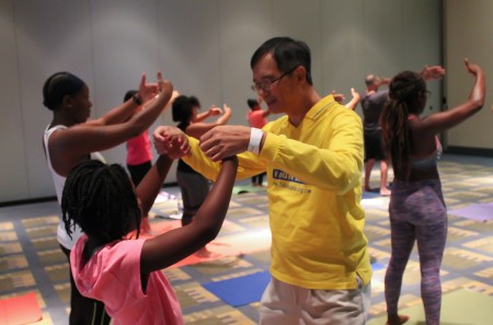 8月20日,美国一年一度的瑜伽博览会(The Yoga Expo)在首都城市华盛顿DC沃尔特.华盛顿会议中心(Walter E. Washington Convention Center)举行。在济济一堂的法轮功功法学习厅内,人们跟着台上法轮功学员范琳莎的讲解,学炼法轮功功法。(于析雨/大纪元)
