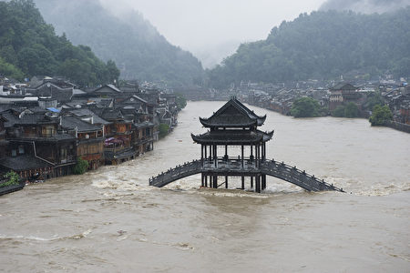 This picture taken on July 15, 2014 shows a bridge submerged in floodwaters in the ancient town of Fenghuang, central China's Hunan province. Rainstorms lashed central China's Hunan Province and southwest China's Guizhou Province, affecting over 1 million people and flooding a historical town, state media reported. CHINA OUT AFP PHOTO / AFP PHOTO / STR