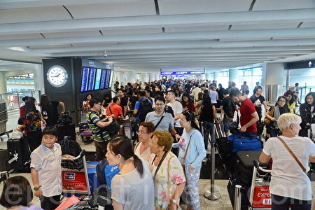 受到台风“妮妲”吹袭香港的影响,大批航班取消,今(2)日下午1点取消8号风球,机场部分飞机复飞,大批旅客为赶离港,大排长龙。(宋祥龙/大纪元)