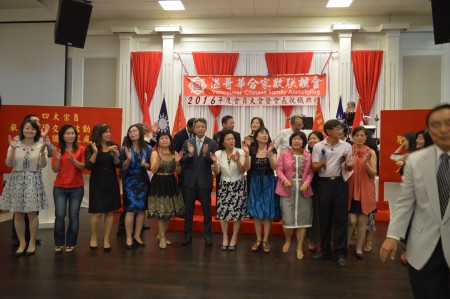圖: 溫哥華合家歡聯誼會會員大會晚宴上,嘉賓、理事與義工合唱“我們都是一家人”會歌。 (邱晨/大紀元)