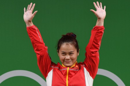 China's Deng Wei celebrates on the podium after she 有关邓薇10年未回家的报导,有人从中看出悲壮,有人看出荒唐,有人看出拼搏,也有人看出功利……(AFP)