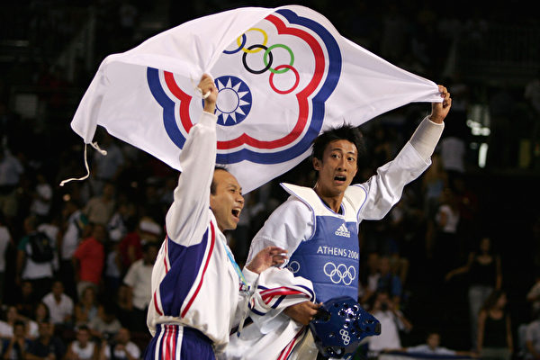 2004年雅典奥运会上,台湾运动员朱木炎获得18公斤跆拳道冠军，跟教练一起庆祝。(Al Bello/Getty Images)