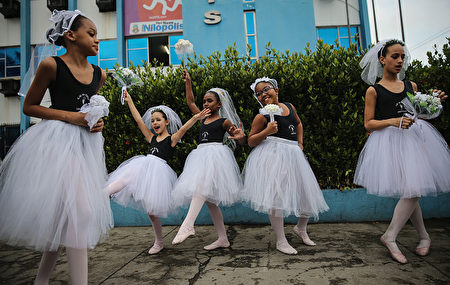 RIO DE JANEIRO, BRAZIL - AUGUST 03: Dancers clown around while waiting to perform ahead of the arrival of the Olympic torch relay in Rio's North Zone on August 3, 2016 in Rio de Janeiro, Brazil. The Rio 2016 Olympic Games commence on August 5. (Photo by Mario Tama/Getty Images)