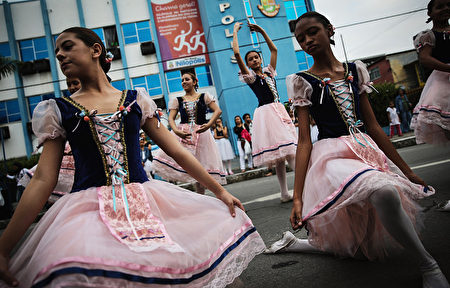 RIO DE JANEIRO, BRAZIL - AUGUST 03: Dancers perform ahead of the arrival of the Olympic torch relay in Rio's North Zone on August 3, 2016 in Rio de Janeiro, Brazil. The Rio 2016 Olympic Games commence on August 5. (Photo by Mario Tama/Getty Images)