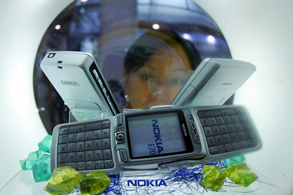 2006年5月,北京一个高科技博览会上,推销员展示新款诺基亚手机。(STR/AFP/Getty Images)