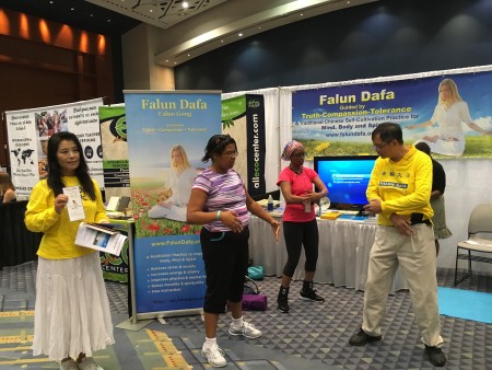 8月20日,美国一年一度的瑜伽博览会(The Yoga Expo)在首都城市华盛顿DC沃尔特.华盛顿会议中心(Walter E. Washington Convention Center)举行。人们在法轮功展位了解和学习法轮功。(于析雨/大纪元)