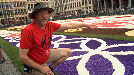 花地毯技术总监 Koen Vondenbusch向记者介绍花地毯的所用花卉。（新唐人）