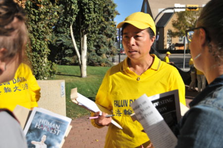 “汽车之旅”负责人之一、来自埃德蒙顿的法轮功学员刘敏楠向到场记者讲法轮功被迫害真相。(黄钟乐/大纪元)