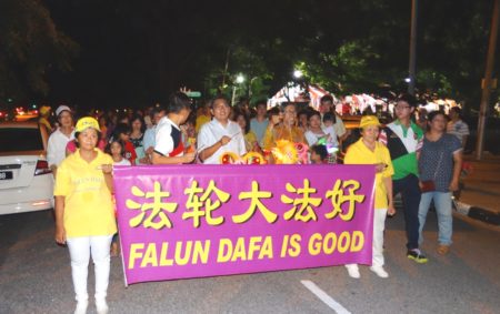 檳城第一副首席部長拿督莫哈末拉昔(橫幅前排衣著長袖巴迪衫者)在主席鄭錦泉等人陪同下,與民眾和法輪功隊伍一起提燈籠遊行慶中秋。(大紀元)