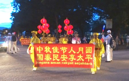 法輪功學員應邀在檳城五條路彩虹公寓,華人集中區遊行與當地民眾歡慶中秋。(大紀元)