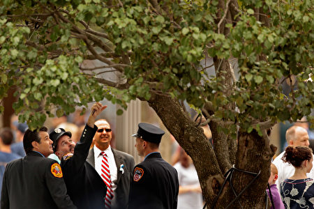 NEW YORK, NY - SEPTEMBER 11: New York Fire Department fire fighters look at the 9/11 survivor tree at the 9/11 Memorial Plaza during the tenth anniversary ceremonies of the September 11, 2001 terrorist attacks at the World Trade Center site, September 11, 2011 in New York City. New York City and the nation are commemorating the tenth anniversary of the terrorist attacks which resulted in the deaths of nearly 3,000 people after two hijacked planes crashed into the World Trade Center, one into the Pentagon in Arlington, Virginia and one crash landed in Shanksville, Pennsylvania. (Photo by Chip Somodevilla/Getty Images)