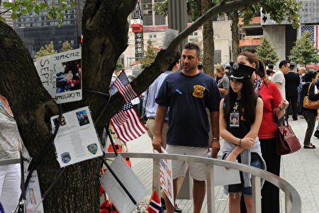 NEW YORK, NY - SEPTEMBER 11: Family members who lost loved ones on 9/11 pause to look at the "Survivor's Tree" inside the Memorial Plaza during the tenth anniversary ceremonies of the September 11, 2001 terrorist attacks at the World Trade Center site, September 11, 2011 in New York City. New York City and the nation are commemorating the tenth anniversary of the terrorist attacks which resulted in the deaths of nearly 3,000 people after two hijacked planes crashed into the World Trade Center, one into the Pentagon in Arlington, Virginia and one crash landed in Shanksville, Pennsylvania. (Photo by Aaron Showalter-Pool/Getty Images)