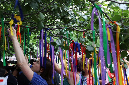NEW YORK, NY - JUNE 16: People tie ribbons on the Survivor Tree at the National September 11 Memorial & Museum in honor of the victims of the Orlando nightclub attack on June 16, 2016 in New York City. Hundreds of people tied colored ribbons on the Survivor Tree at the National September 11 Memorial & Museum to honor the victims of the terror attack at the Pulse nightclub in Orlando over the weekend that left 49 dead. (Photo by Justin Sullivan/Getty Images)