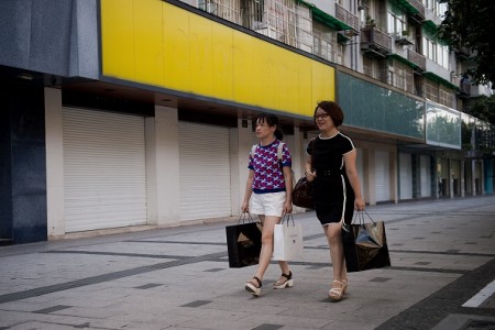 9月2日,两名女子经过几乎全部关闭的街道商店门前。(NICOLAS ASFOURI/AFP/Getty Images)