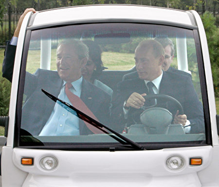 2006年7月15日,普京在聖彼得堡駕駛一輛高爾夫球車,載布什。(DMITRI ASTAKHOV/AFP/Getty Images)