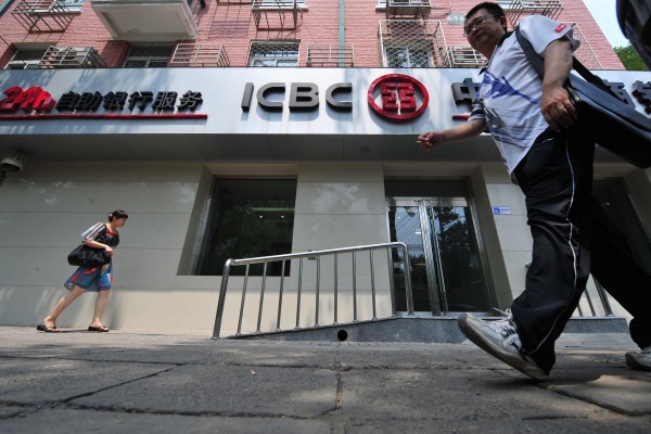 TO GO WITH China-finance-economy-business-company-Fortune,ANALYSIS by D'Arcy Doran This photo taken on July 21, 2009 shows people walking past a branch of the Industrial and Commercial Bank of China (ICBC) in Beijing. Heads may have turned when more Chinese firms than ever made Fortune's list of 500 top global companies, but experts say the increase reflects Beijing's power, not companies' competitiveness, after an unprecedented 34 firms from mainland China made the list of the world's top companies by revenue, up from 25 last year. The Chinese firms may not be global household names, but the impact of companies like ICBC, which leads the pack of the world's top five banks all from China as the world's most profitable bank with a pretax profit of 21.3 billion USD is felt around the world as they jostle with other Fortune 500 firms to snap up acquisitions. AFP PHOTO / Frederic J. BROWN (Photo credit should read FREDERIC J. BROWN/AFP/Getty Images)