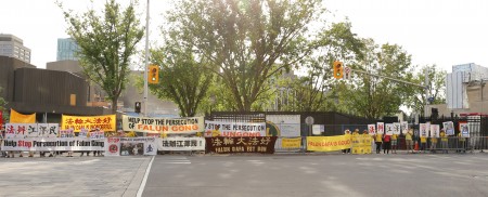 法轮功学员在酒店前,通过横幅向李克强一行传达讯息——停止迫害、法办江泽民。(梁耀/大纪元)