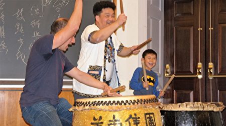 王宏隆(中)與觀眾互動,演示舞獅的打鼓技巧。(貝拉/大紀元)