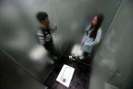 This photo taken on September 29, 2016 shows tourists visiting a glass-walled public toilet in Shiyan Lake scenic area in Changsha, central China's Hunan province. The glass toilet was open for the public from September 29. / AFP / STR / China OUT (Photo credit should read STR/AFP/Getty Images)