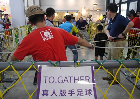 “真人版手足球赛”是项适合大人小孩共同玩乐的室内活动。(方金媛/大纪元)