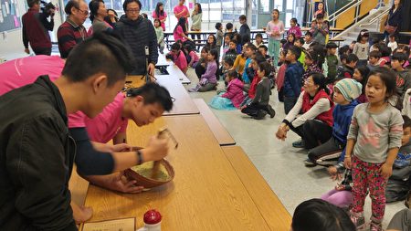 温哥华地区FASCA青少年文化大使正在向学生们演示如何制作客家擂茶。 (邱晨/大纪元)