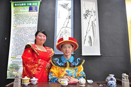 中國綠茶的茶席,穿著龍袍的男學生扮成帥氣皇帝和貴妃微笑著,模樣煞是可愛。(賴月貴/大紀元)